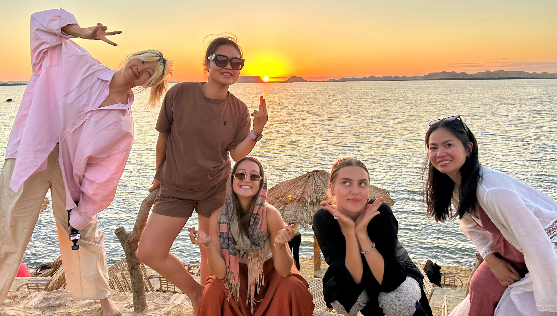 Friends playing together at sunset by the lake in Siwa